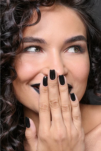 woman face covered with hands black nails